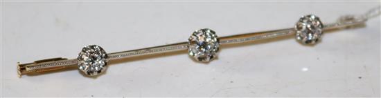 A mid 20th century French 18ct gold, platinum and three stone diamond set bar brooch, approx. 2.75in.